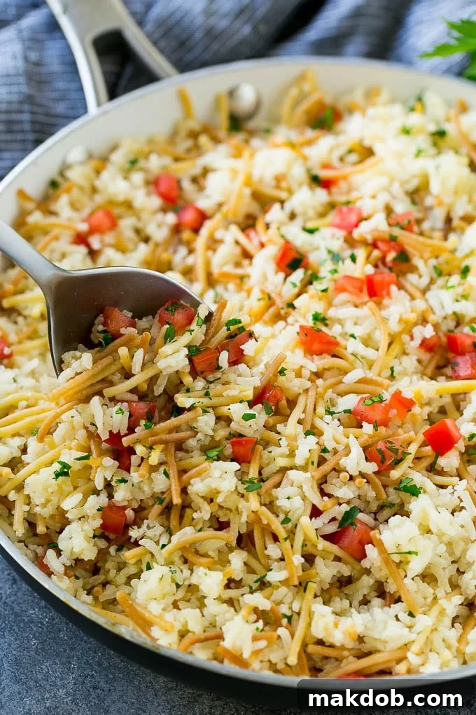 A skillet of chicken rice-a-roni made with pasta, rice and fresh tomatoes.