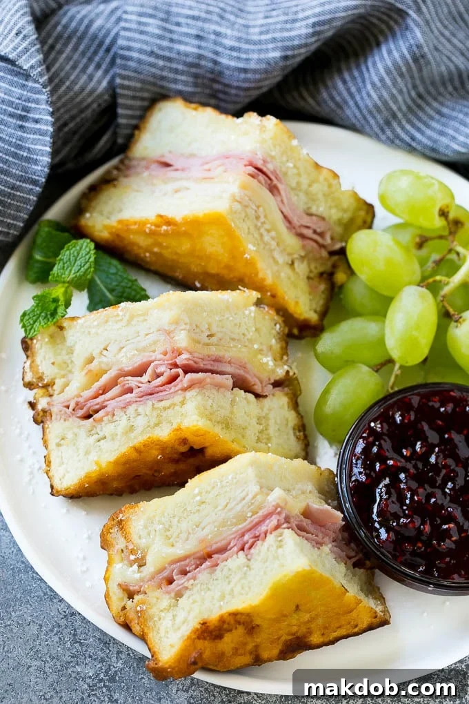 Disneyland Monte Cristo Sandwich 2 A plate of Monte Cristo sandwich with fresh fruit and raspberry jam for dipping.