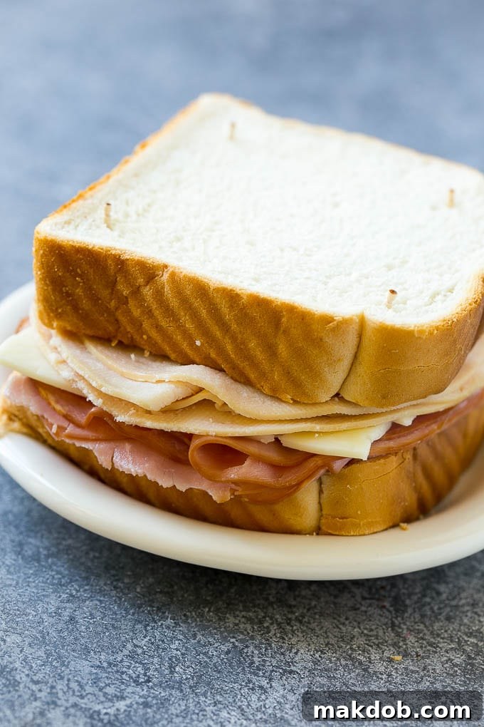 Disneyland Monte Cristo Sandwich 3 An uncooked Monte Cristo sandwich with bread, ham, turkey and cheese.
