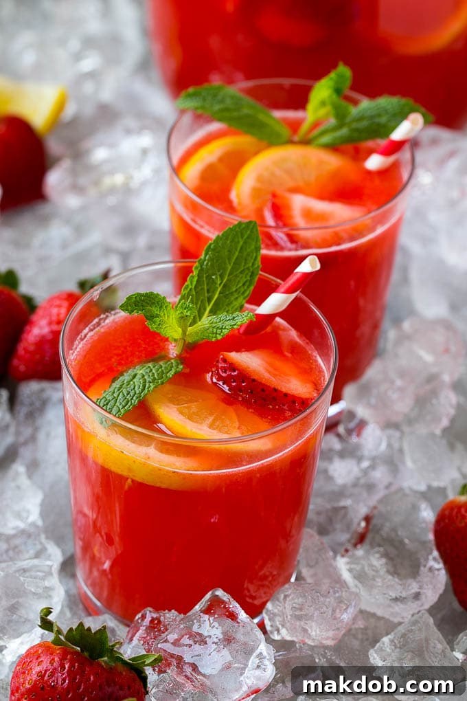 Strawberry Lemonade Recipe | Homemade Lemonade | Strawberry Drink Recipe #lemonade #strawberries #drink #dinneratthezoo Several glasses of homemade strawberry lemonade, each adorned with fresh mint sprigs and lemon slices, are perfectly chilled and ready to be enjoyed on a warm day.