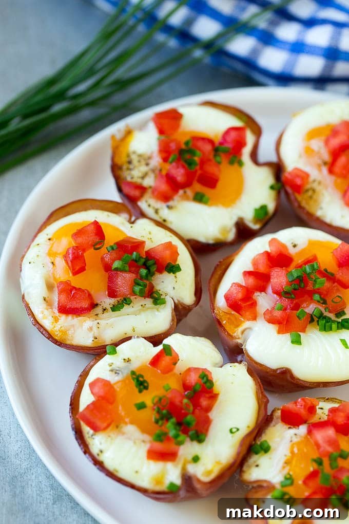 Baked Ham and Egg Cups | Breakfast or Brunch Option A plate of freshly baked ham cups, filled with fluffy eggs and melted cheese, ready for toppings.