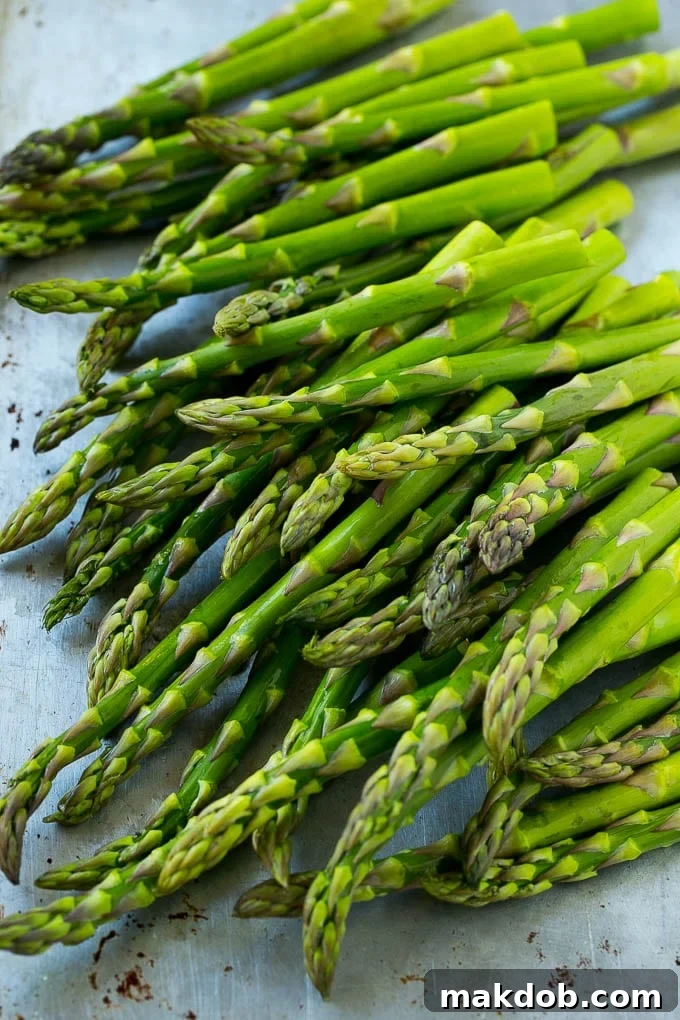 Fresh raw asparagus stalks on a sheet pan.