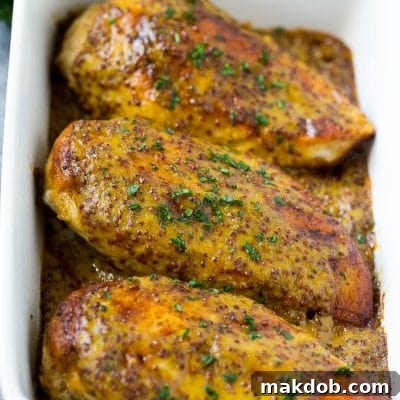 Baked honey mustard chicken garnished with chopped parsley.