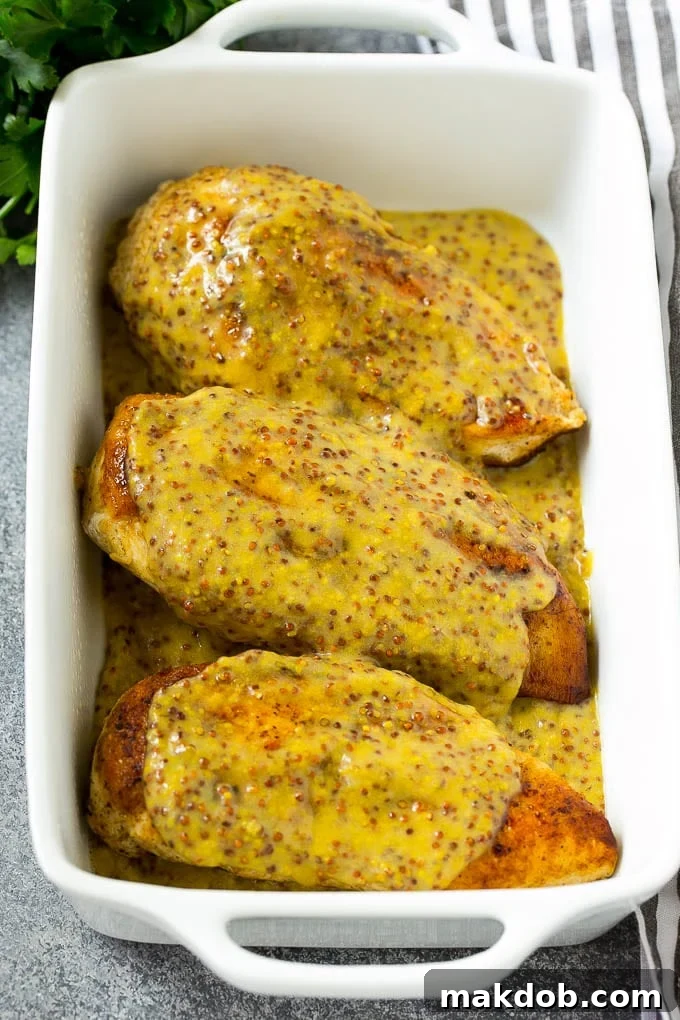 Chicken breasts in a baking dish topped with sauce.