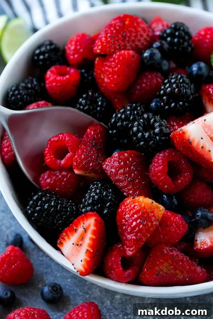 Berry Fruit Salad Recipe | Berry Salad | Summer Berry Salad | Fruit Salad Recipe #berries #fruitsalad #dinneratthezoo A bowl of berry fruit salad with a serving spoon in it.