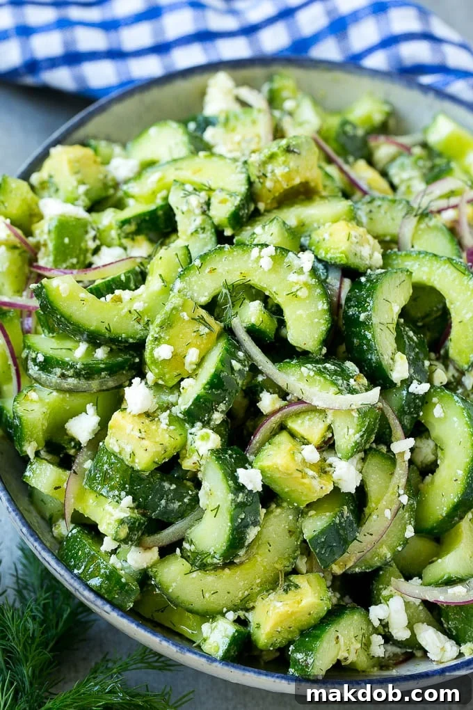 Vibrant cucumber feta salad, brimming with sliced cucumbers, creamy avocado, fresh dill, thinly sliced red onions, and crumbled feta cheese, all expertly tossed in a zesty Greek-style dressing.