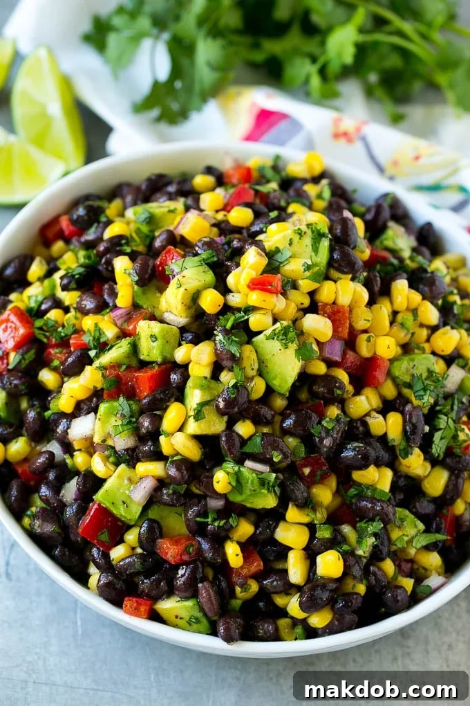 Black Bean and Corn Salad Serving A serving bowl of black bean salad featuring corn, peppers, and avocado, ready for sharing.