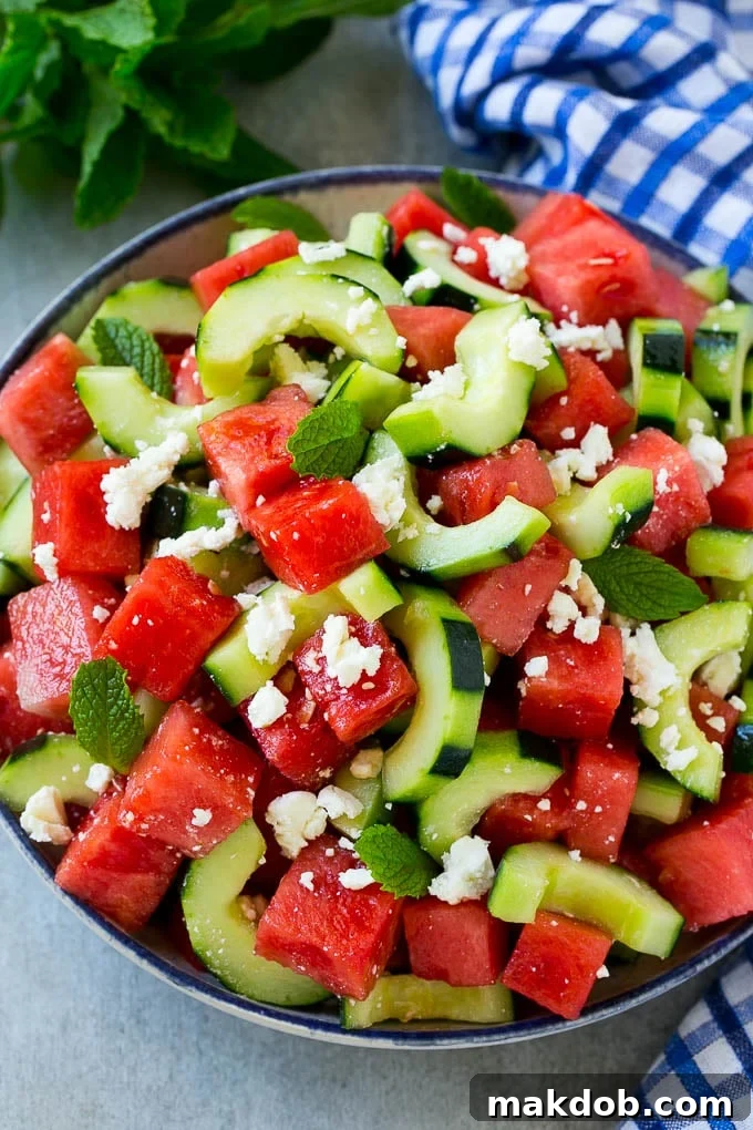 A beautifully presented bowl of watermelon feta salad, generously garnished with fresh mint leaves and a delicate lime dressing, ready for serving.