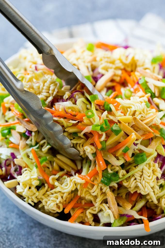 Ramen noodle salad with tongs scooping it out.