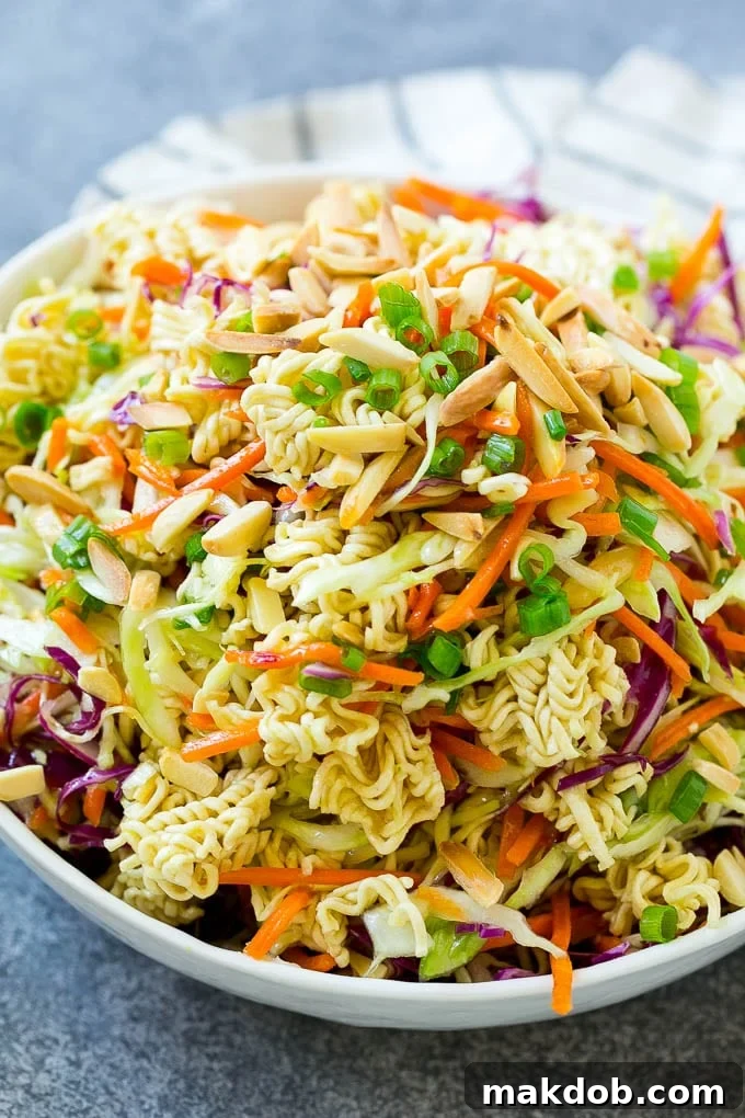 Ramen noodle salad full of shredded cabbage, sliced almonds, carrots and green onions.