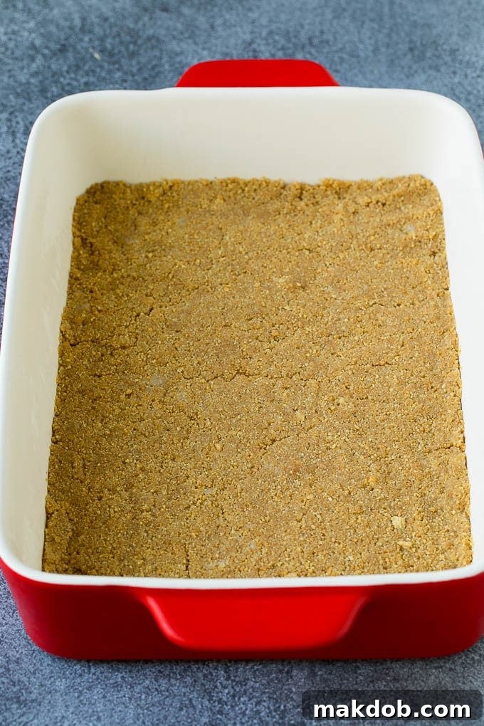 Banana Split Cake Recipe | No Bake Cake | Banana Split Dessert #banana #chocolate #nobake #cake #cheesecake #dinneratthezoo A graham cracker crust in a rectangular baking dish.