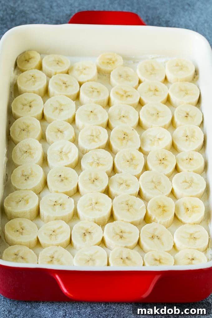 Banana Split Cake Recipe | No Bake Cake | Banana Split Dessert #banana #chocolate #nobake #cake #cheesecake #dinneratthezoo A layer of bananas on top of a cheesecake mixture.
