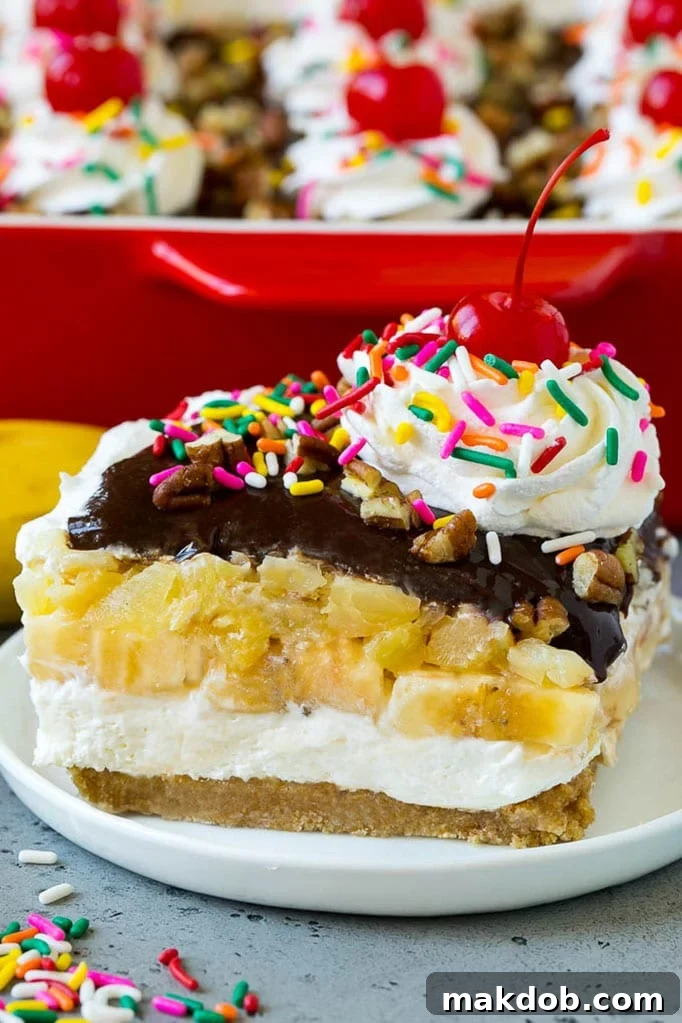 Banana Split Cake Recipe | No Bake Cake | Banana Split Dessert #banana #chocolate #nobake #cake #cheesecake #dinneratthezoo A slice of banana split cake with layers of graham cracker, cheesecake, bananas and pineapple.