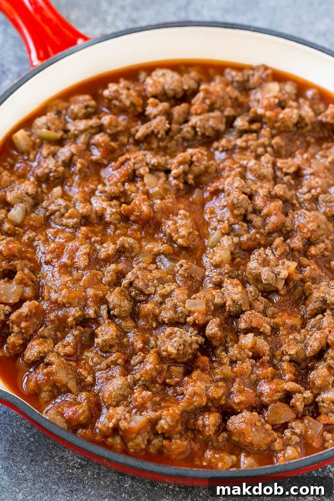 Ground beef, onions and tomato sauce in a skillet