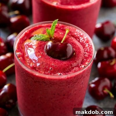 Refreshing Cherry Smoothie 2 A cherry smoothie garnished with a fresh dark cherry and mint.