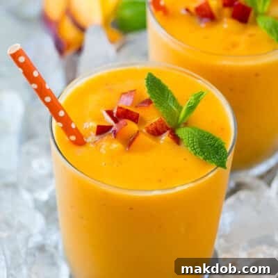 A peach smoothie in ice garnished with mint.