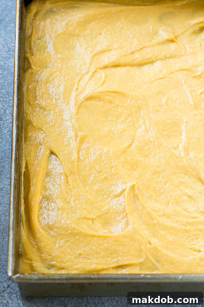 A layer of peanut butter filling on top of chocolate cake crust in a baking pan.