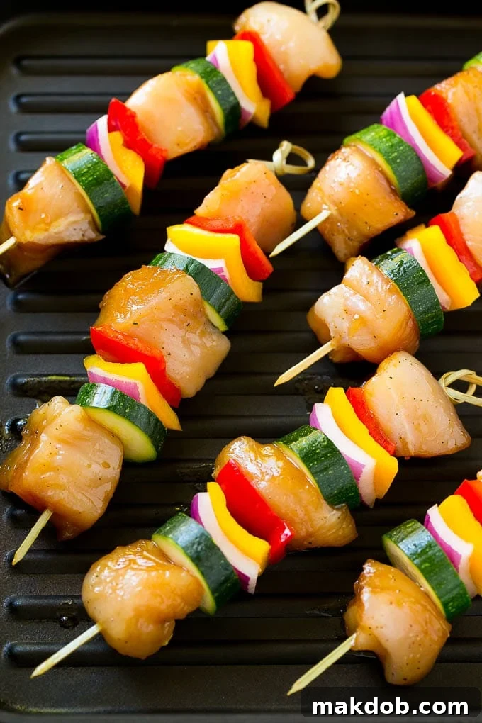 Marinated chicken and vegetable kabobs cooking on a hot grill pan, showing delicious char marks.