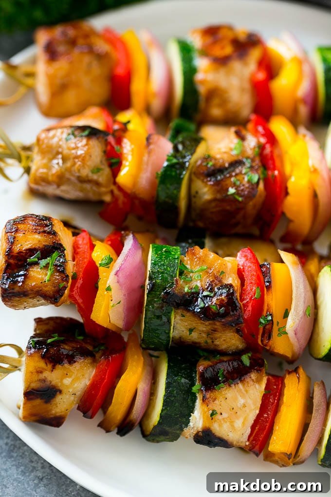 Close-up of freshly grilled chicken kabobs featuring vibrant peppers, red onion, and tender zucchini, ready to be served.