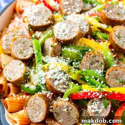 Hearty Italian Sausage and Bell Pepper Pasta 2 Sausage and pepper pasta with sliced Italian sausage, red and yellow bell peppers and grated parmesan cheese.