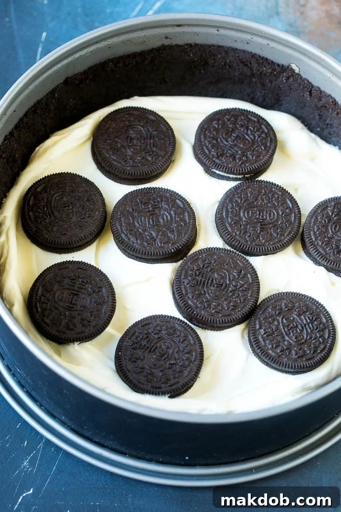 Ultimate No-Bake Oreo Cheesecake 4 Layers of creamy no bake cheesecake filling alternating with whole Oreo cookies inside a springform pan, before the final topping.