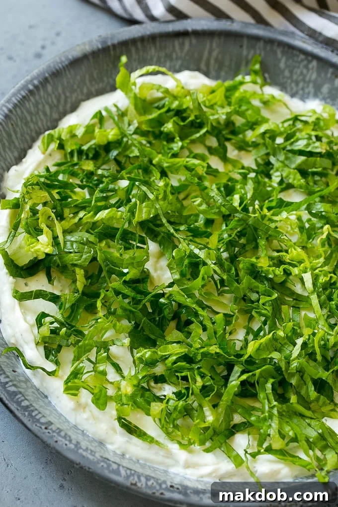 The Ultimate BLT Dip 4 A layer of finely shredded romaine lettuce spread over the creamy sour cream, cream cheese, and ranch base of the BLT dip.