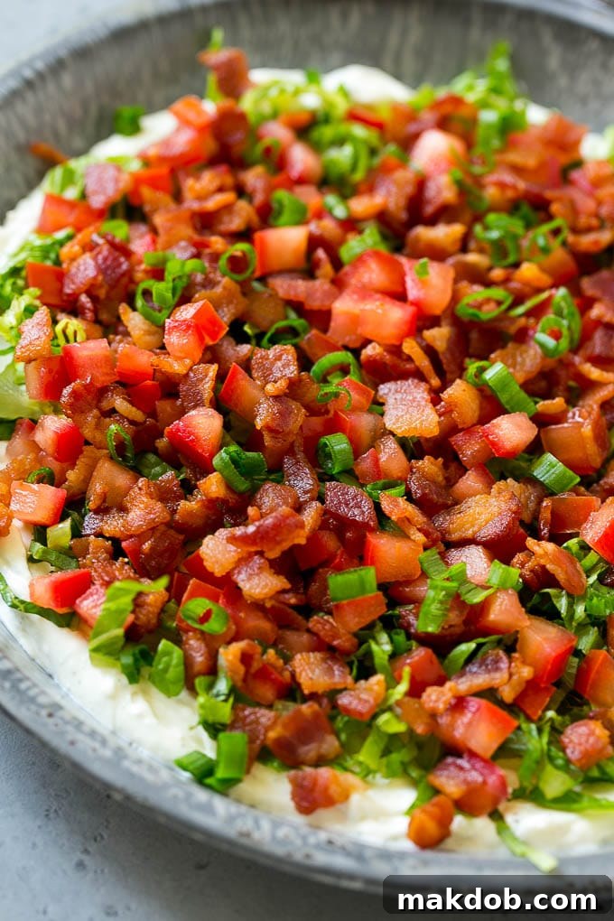 The Ultimate BLT Dip 6 The finished BLT dip, showcasing its creamy ranch base, topped generously with crisp lettuce, juicy tomatoes, and smoky bacon, ready for serving.