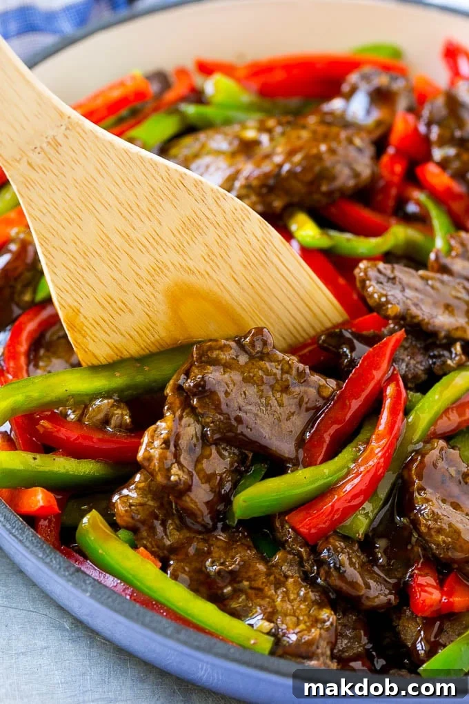 Pepper Steak Stir Fry Recipe | Chinese Pepper Steak | Steak Stir Fry | Beef Stir Fry #steak #peppers #stirfry #chinesefood #dinneratthezoo #beef Pepper steak stir fry with a serving utensil in it.