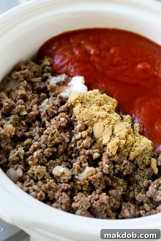 Slow Cooker Sloppy Joes Recipe | Crock Pot Sloppy Joes | Homemade Sloppy Joes #beef #slowcooker #crockpot #sandwich #dinneratthezoo Ground beef, onions, tomato sauce, brown sugar and spices in a slow cooker.