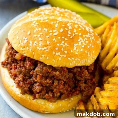 Ultimate Slow Cooker Sloppy Joes 2 Slow cooker sloppy joe on a bun served with fries and pickles.