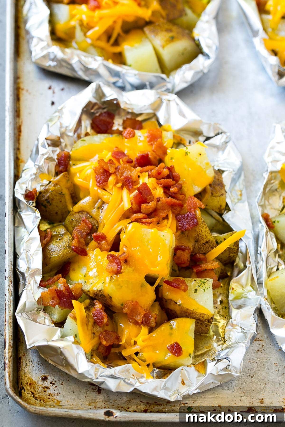 Grill-Wrapped Potatoes 5 Cooked potatoes with shredded cheese and bacon on top.