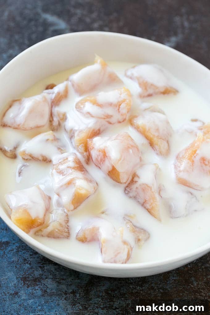Chicken breast pieces soaking in buttermilk.