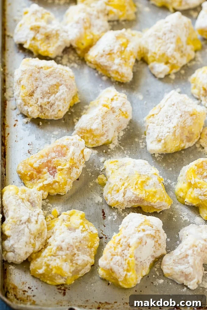Chicken breast pieces coated in eggs and seasoned flour.