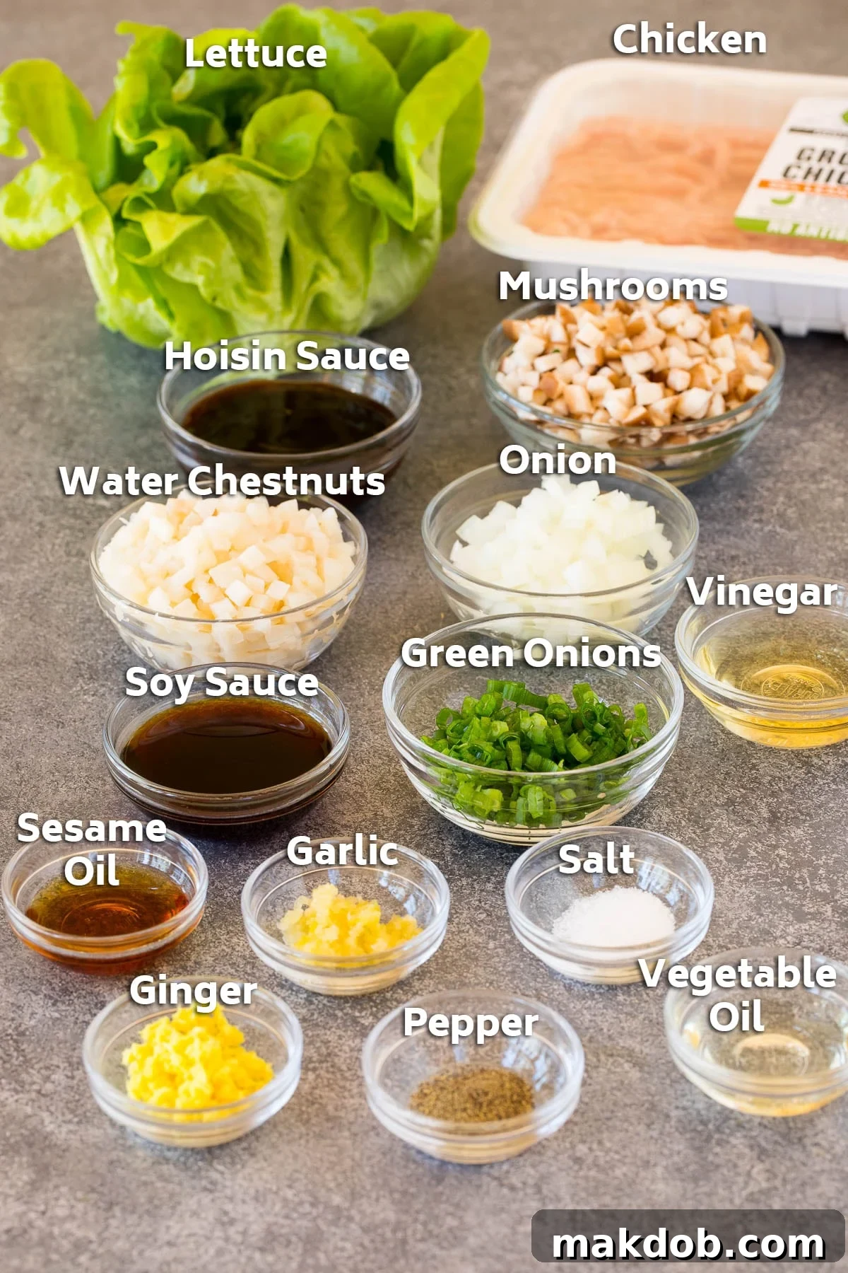 A vibrant display of ingredients including lean ground chicken, fresh vegetables like mushrooms and onions, and a crisp head of butter lettuce, ready for preparation.