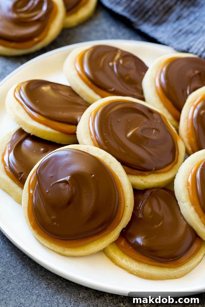 A plate of perfectly arranged Twix cookies, showing their layered construction of shortbread, caramel, and chocolate.