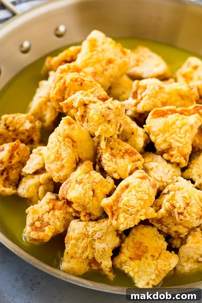 Chinese Lemon Chicken Recipe | Crispy Lemon Chicken | Chinese Food Recipe #lemon #chicken #chinesefood #dinner #dinneratthezoo Fried chicken pieces in a pan of lemon sauce.