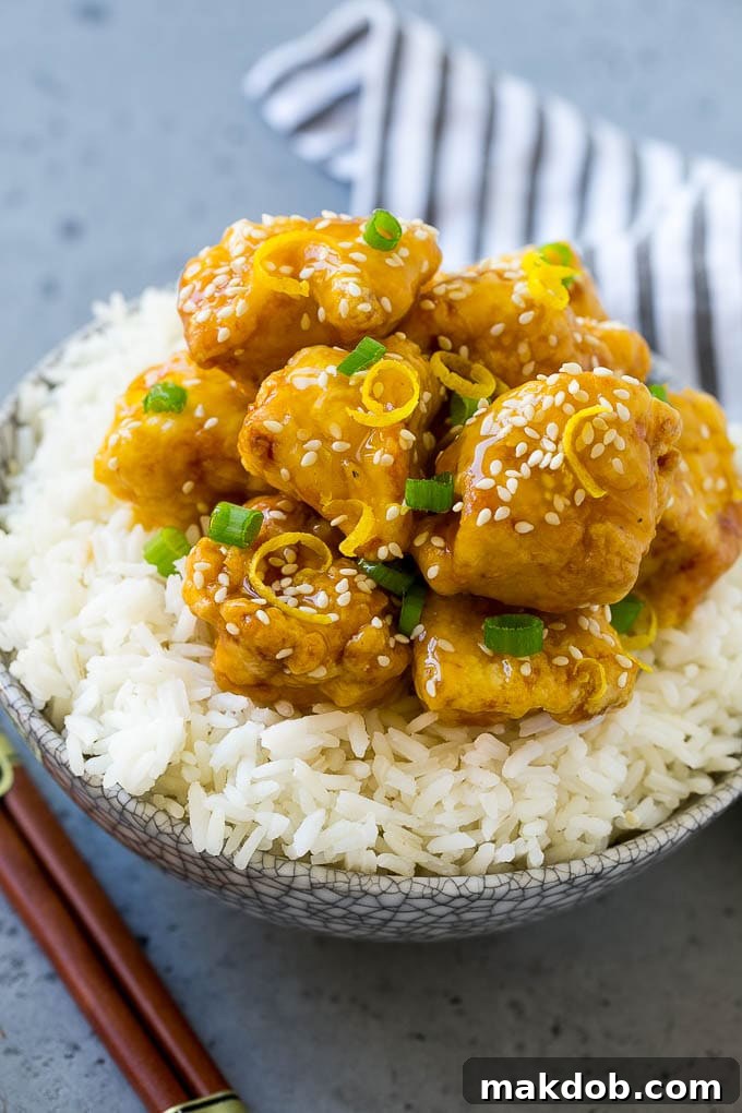 Chinese Lemon Chicken Recipe | Crispy Lemon Chicken | Chinese Food Recipe #lemon #chicken #chinesefood #dinner #dinneratthezoo Chinese lemon chicken served over rice with chopsticks.