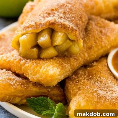 Crispy Fried Apple Delights 2 Fried apple pies on a plate served with caramel sauce and topped with cinnamon sugar.