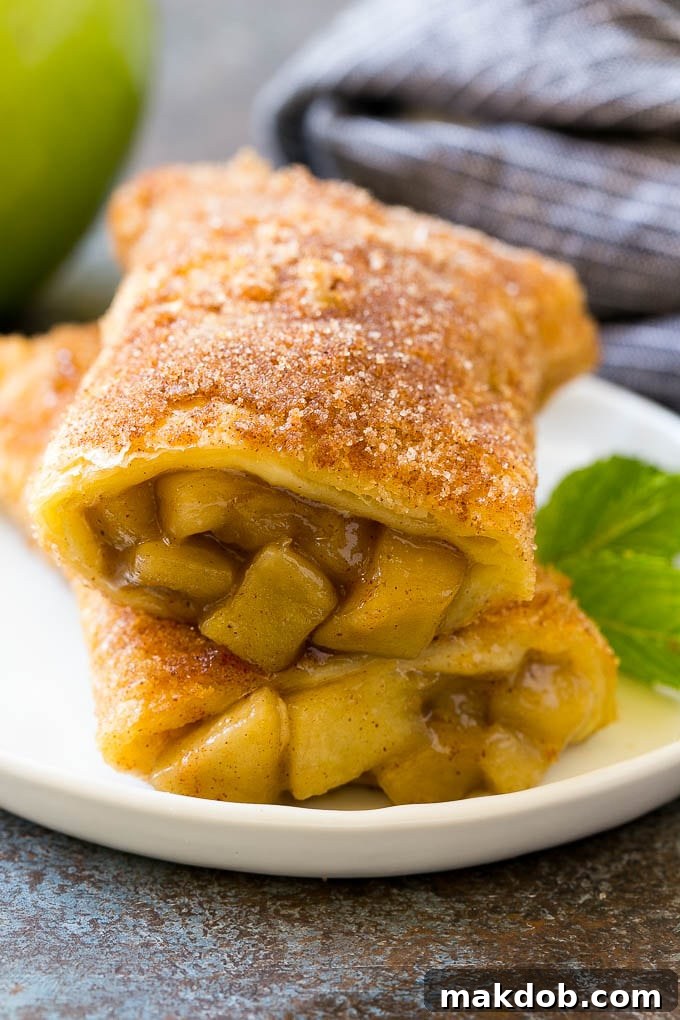 Fried Apple Pies Recipe | McDonald's Copycat Recipe | Apple Pie | Apple Hand Pies #pie #apples #applepie #dessert #snack #dinneratthezoo A cross section of a fried apple pie on a plate.