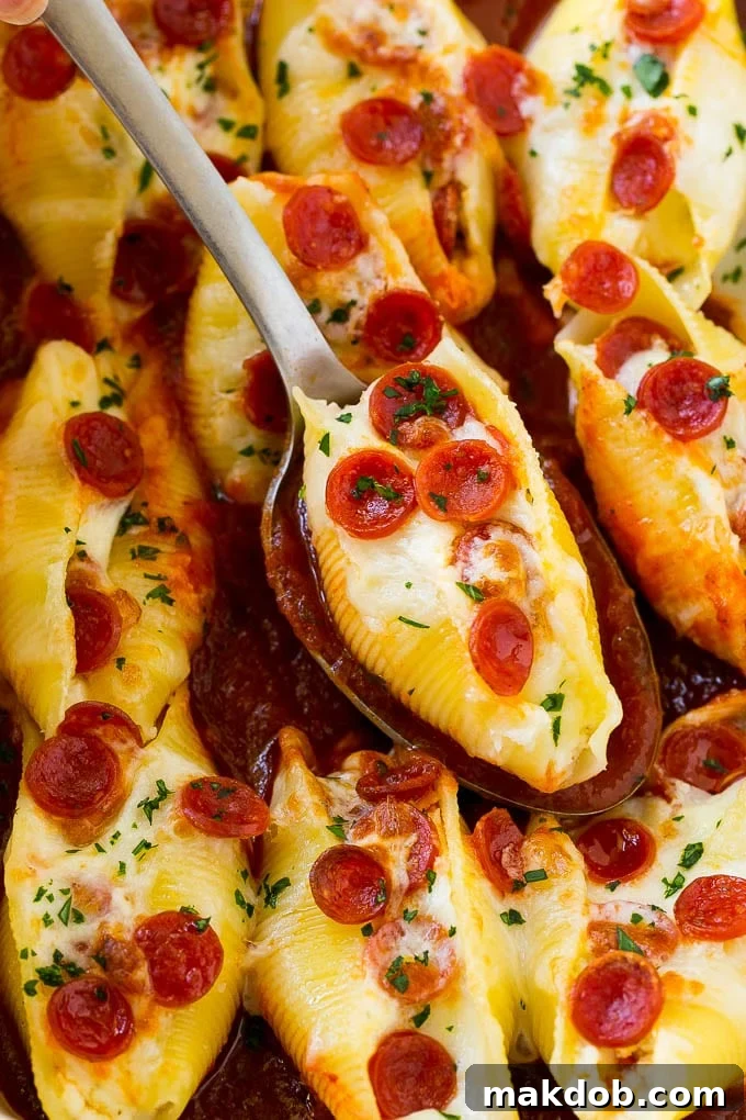Pizza Stuffed Shells | Stuffed Shells Recipe | Italian Stuffed Shells #pizza #pasta #cheese #pepperoni #dinner #dinneratthezoo Pizza stuffed shells with a serving spoon.