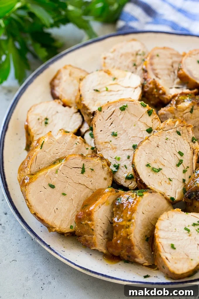 Slow Cooker Pork Tenderloin Recipe | Crock Pot Pork Tenderloin | Easy Pork Tenderloin #slowcooker #crockpot #pork #dinner #dinneratthezoo Sliced slow cooker pork tenderloin on a plate.