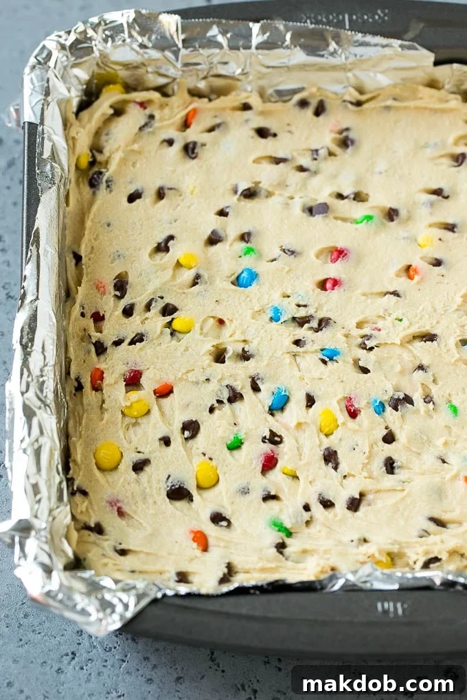 Edible cookie dough spread into a square baking pan.