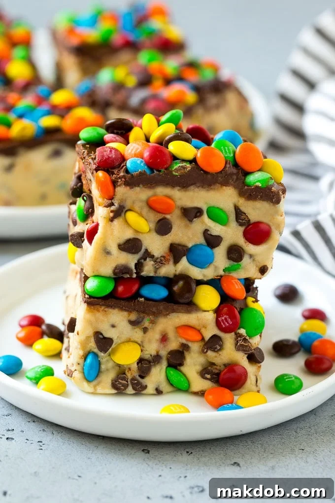 Cookie dough bars stacked on top of each other on a plate.