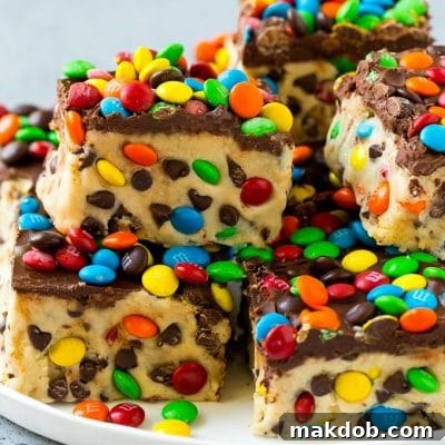 A plate of cookie dough bars studded with chocolate chips and M&M's.