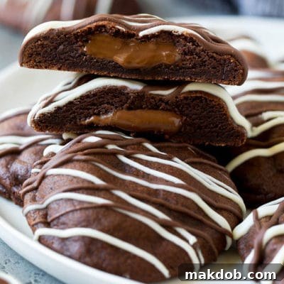 A serving plate of Nutella cookies with one cut in half, showcasing the gooey Nutella center.