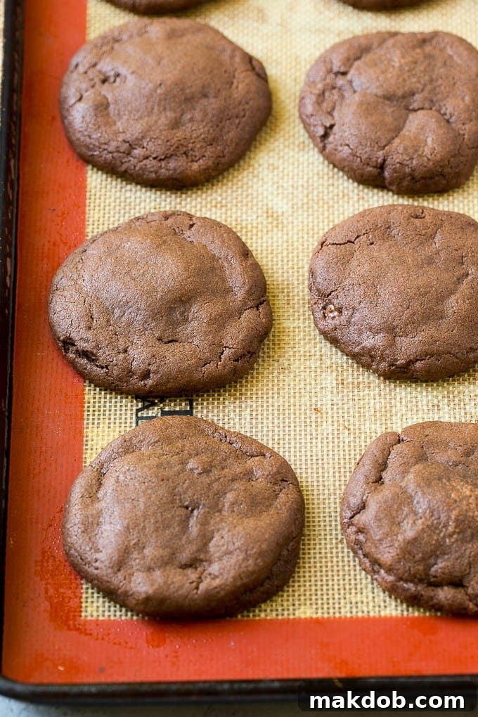 Baked Nutella Stuffed Cookies Freshly baked chocolate cookies stuffed with Nutella on a wire cooling rack.