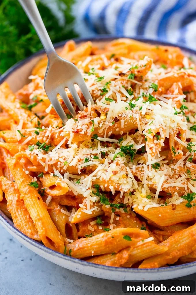 A bowl of penne alla vodka with a fork in it.