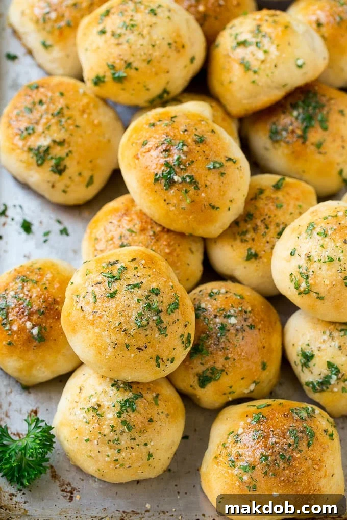 Freshly baked cheese bombs, perfectly golden brown and glistening with garlic butter, arranged on a sheet pan, ready to be served.