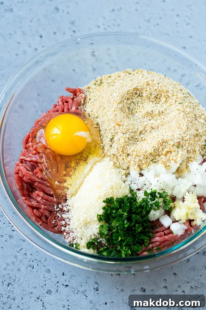 Classic Italian Slow Cooker Meatballs 3 Ground beef, onion, garlic, herbs, cheese and breadcrumbs in a mixing bowl.