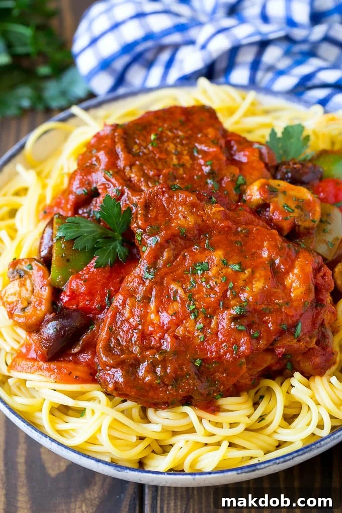 Slow Cooker Chicken Cacciatore Recipe | Italian Chicken #chicken #crockpot #slowcooker #dinner #italianfood #peppers #dinneratthezoo Slow cooker chicken cacciatore served over spaghetti.